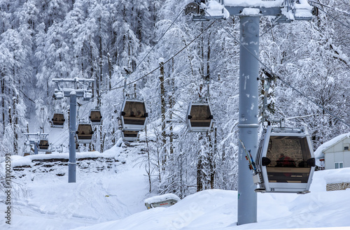 Cable car ski cabin lift line of a ski mountain resort on snowy winter forest background. Beautiful scenic landscape