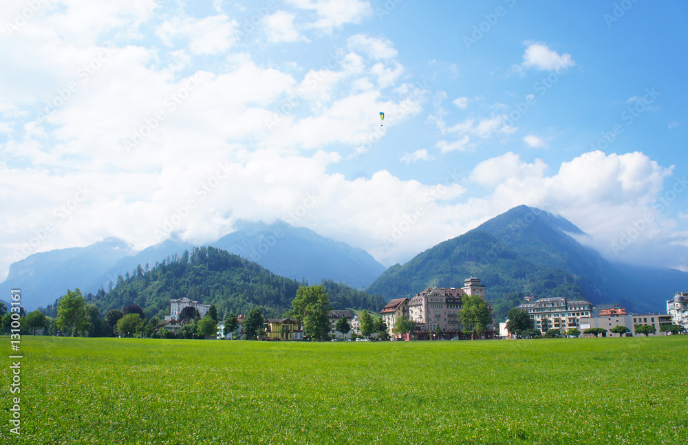 Landscape of Interlaken with green field, buildings and alps mountain