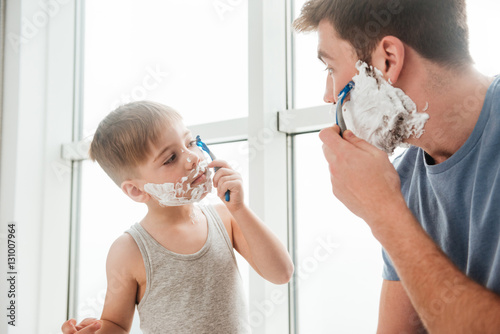 Father and son are shaving in bathroom photo