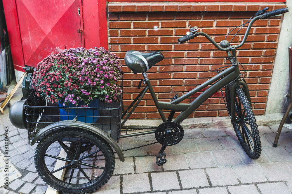 Street decoration with old bicyle and big basket of flowers