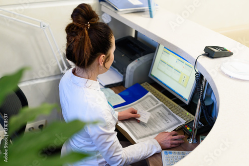 Vászonkép Female receptionist working the computer