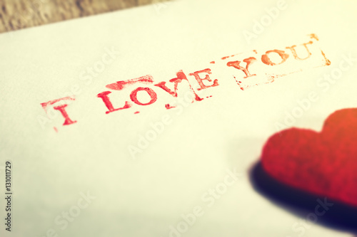 Envelope with message I love you and hearts on a wooden backgrou