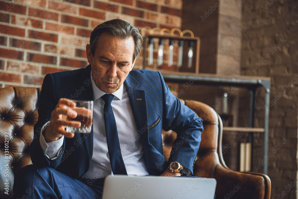 Tired senior businessman drinking whiskey