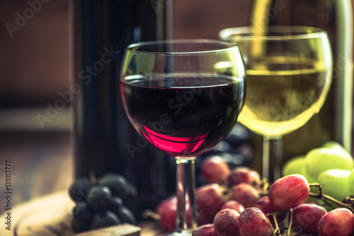glass with red wine, cork and fresh grapes