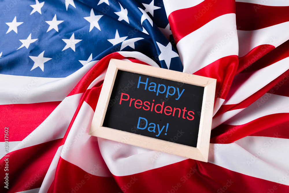 Φωτογραφία the text happy presidents day written in a chalkboard and a flag of the United S