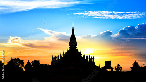 Laos travel landmark  golden pagoda wat Phra That Luang at sunset sky in Vientiane  Buddhist temple  Religious architecture and landmarks  Famous tourist destination in Asia.