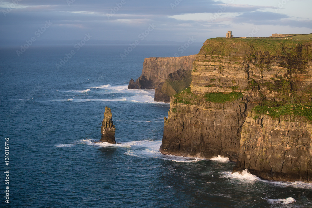 Yellow rocks of Cliffs of Moher, Ireland lighted up with the setting sun