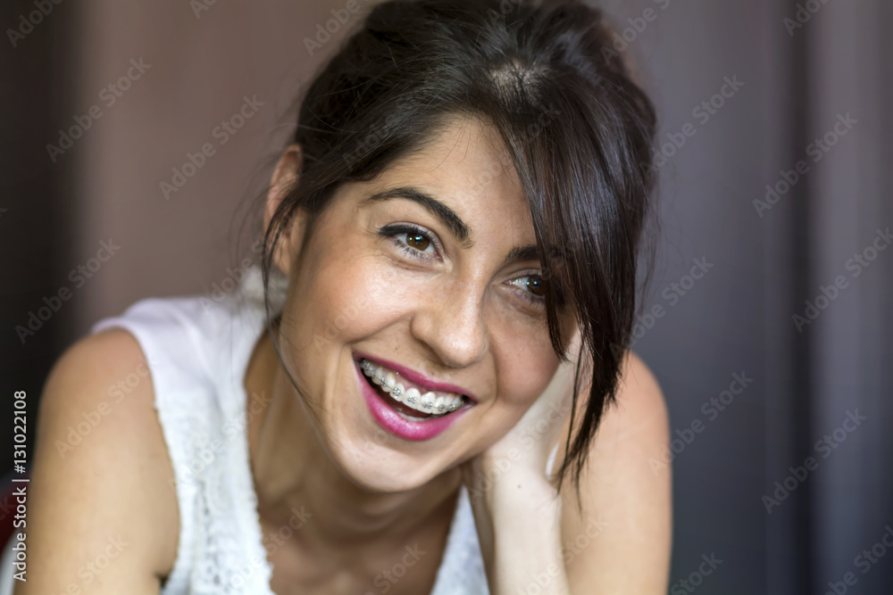 Naklejka premium Portrait of a beautiful woman with braces on teeth. Orthodontic Treatment. Dental care Concept