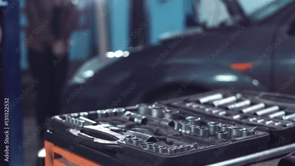 Man repairing engine taking screwdriver from toolbox Man repairing engine taking screwdriver from toolbox