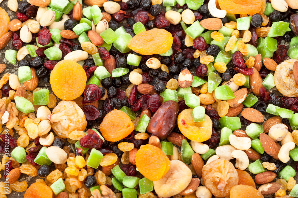 Background of mixed dried fruits (raisins, apricots, figs, prunes, goji, cranberries, blueberries, prunes) and nuts (almonds, hazelnuts, peanuts, cashews)