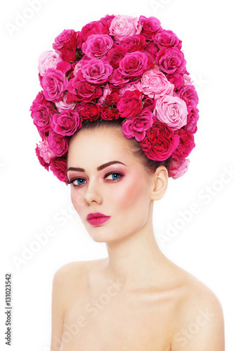 Young beautiful woman with stylish make-up in fancy vintage style wig of pink roses over white background