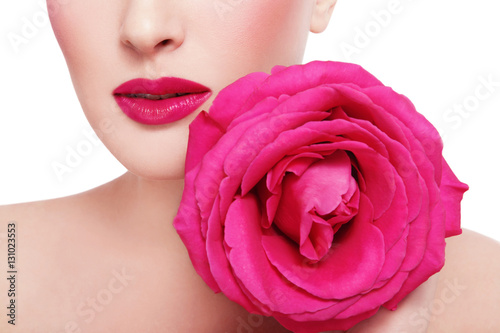 Close-up shot of woman s lips with fuchsia lipstick and beautiful hot pink rose over white background