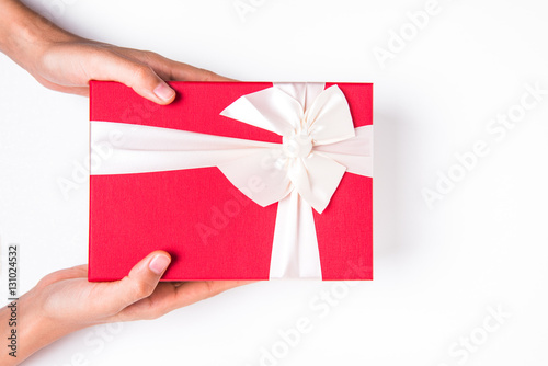 Close up shot of female hands holding a small gift wrapped with brown ribbon.  © siwarit01