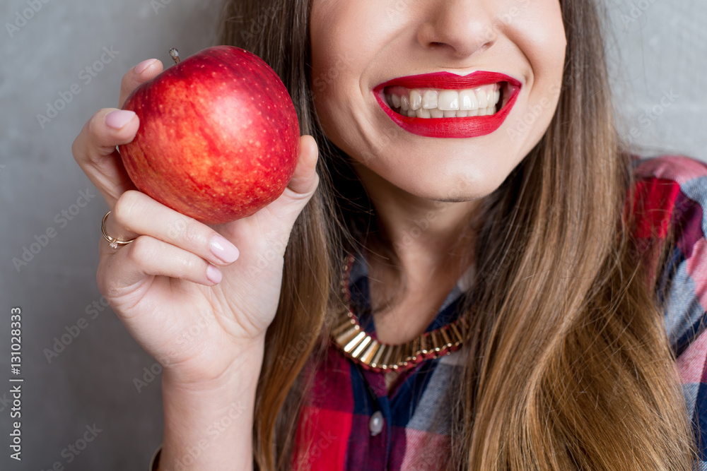 Close up view on the woman with healthy toothy smile and red apple Close up view on the woman with healthy toothy smile and red apple