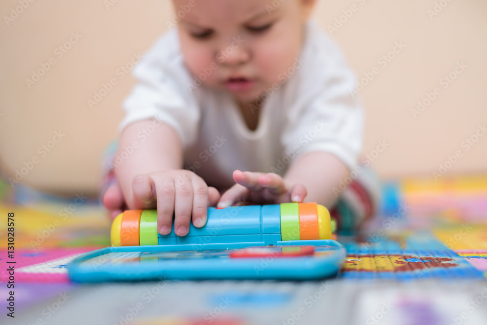 cheerful kid playing with toys on the floor cheerful kid playing with toys on the floor