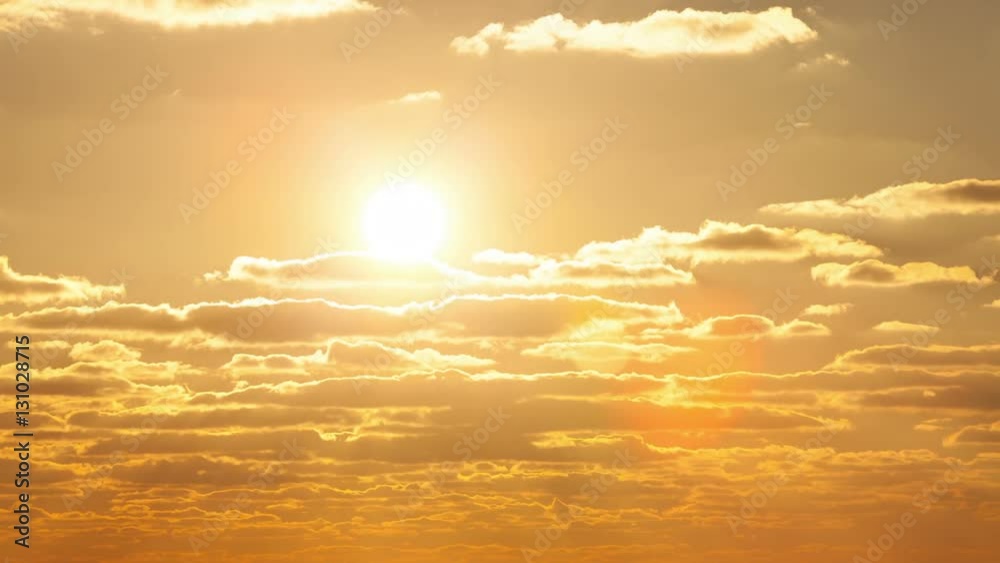 The sun floating in the clouds at sunset. Timelapse