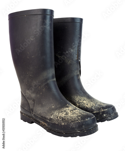 Three quarter view of a dirty pair of black rubber boots. Iolated. Vertical.