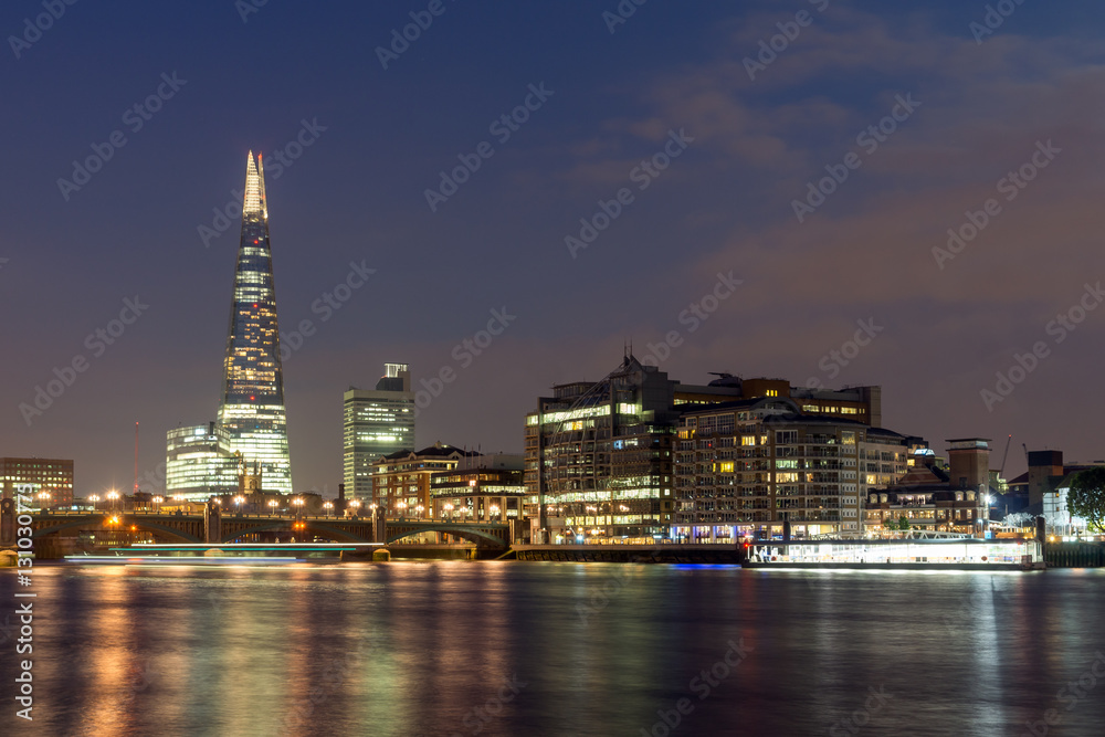 LONDON, ENGLAND - JUNE 17 2016: Night Panorama of Southwark Bridge, The Shard  skyscraper and Thames River, London, United Kingdom