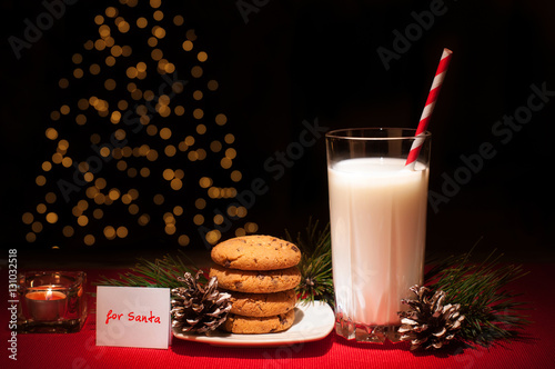 Christmas cookies milk note for Santa in front of lights new year tree photo