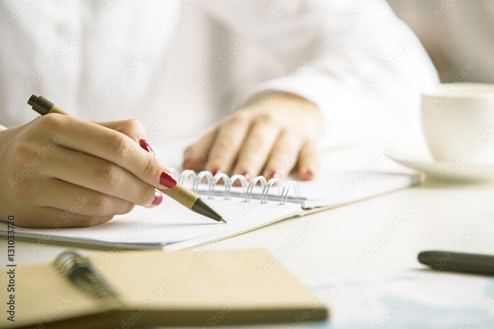 Female writing in notepad Female writing in notepad