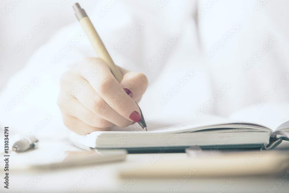 Woman writing in notepad Woman writing in notepad