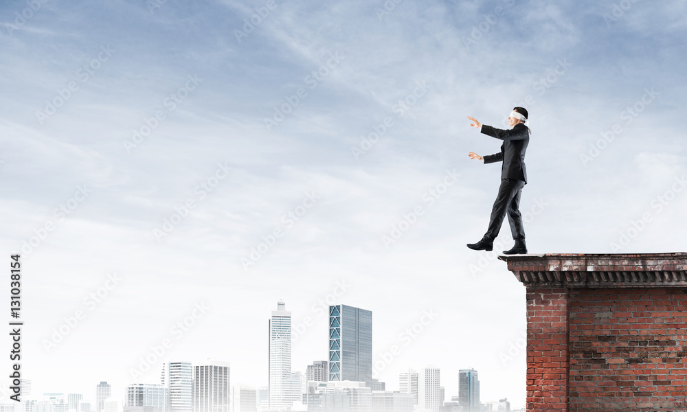 Danger and risk concept with businessman making step from edge Danger and risk concept with businessman making step from edge