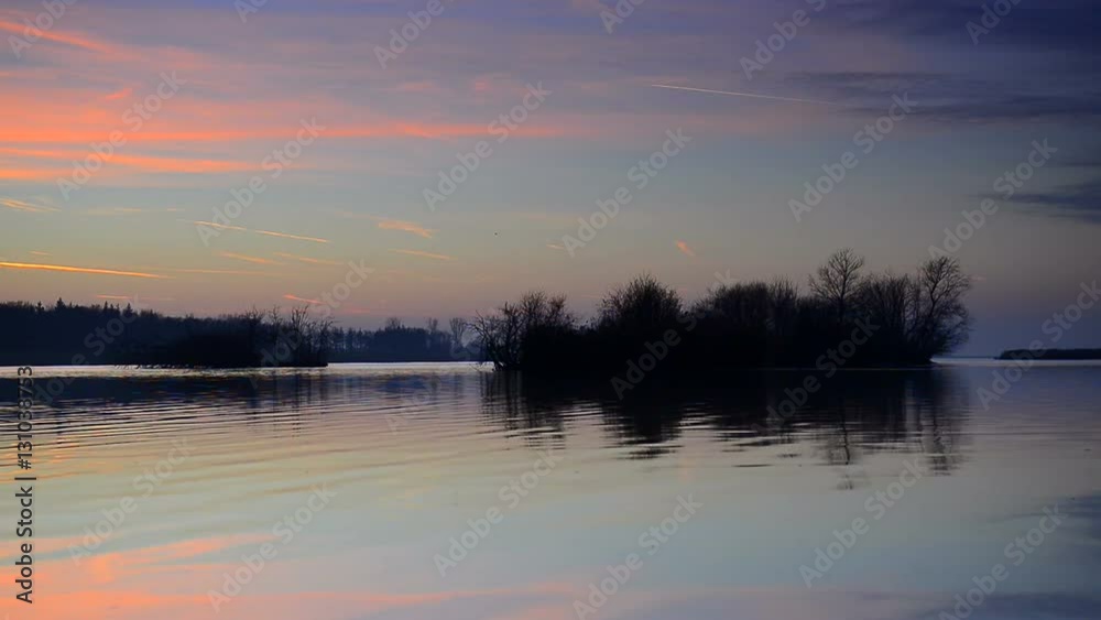 Sunset over a lake with small islands at the end of a winter day. Sunset over a lake with small islands at the end of a winter day.