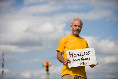 Homeless man with a sign asking for help.