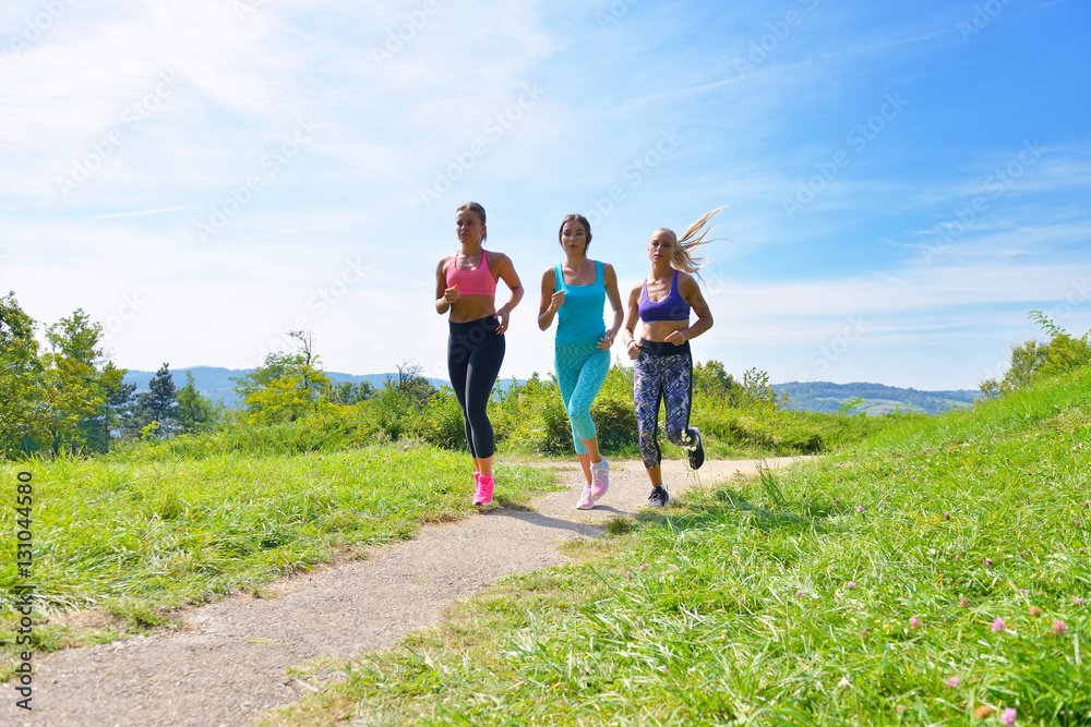 Three Female Joggers running together outdoors Three Female Joggers running together outdoors