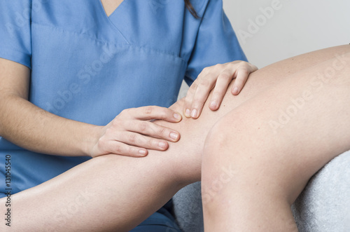 Physiotherapist, chiropractor doing a patellar mobilization, Kne