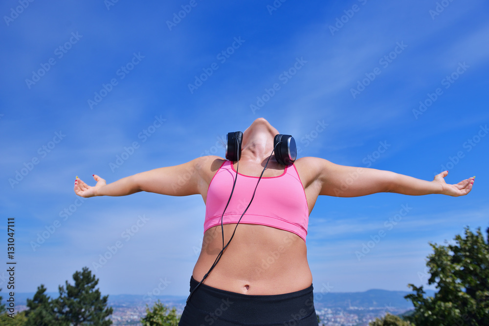 Success fitness winning woman concept with earphones.