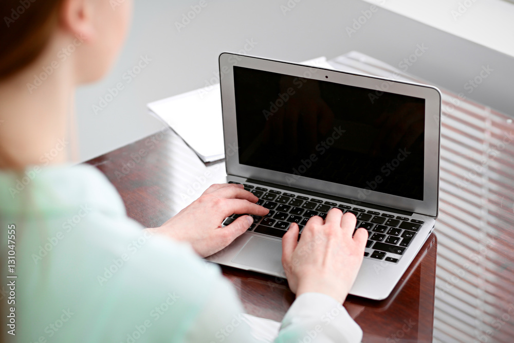 Business woman hands in a green blouse sitting at the desk in the office and typing on the laptop . Business woman hands in a green blouse sitting at the desk in the office and typing on the laptop .