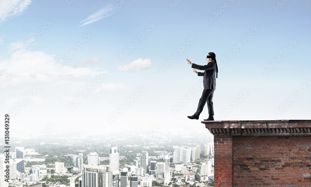Danger and risk concept with businessman making step from edge Danger and risk concept with businessman making step from edge