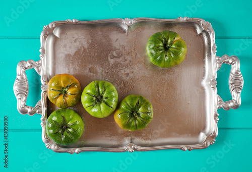 Quadro su tela green heirloom tomatoes on silver tray on Iris Blue background