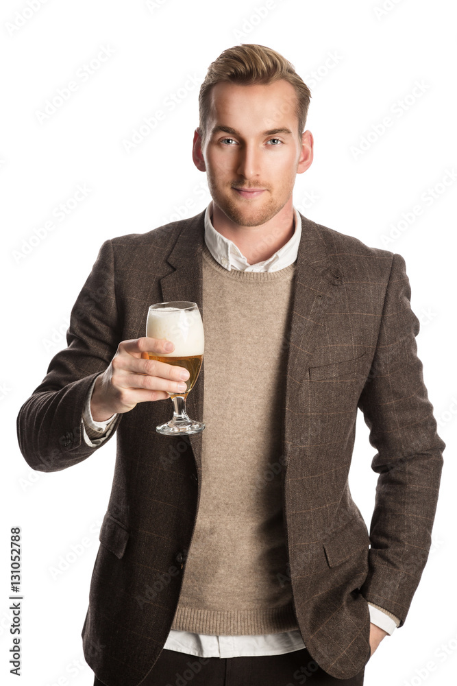 Handsome man wearing a brown jacket and shirt, standing against a white background smiling holding a beer glass in his hand.