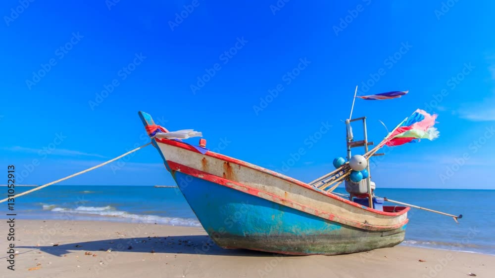 the alone fishing boat on the beach with blue sky in Thailand ocean the alone fishing boat on the beach with blue sky in Thailand ocean