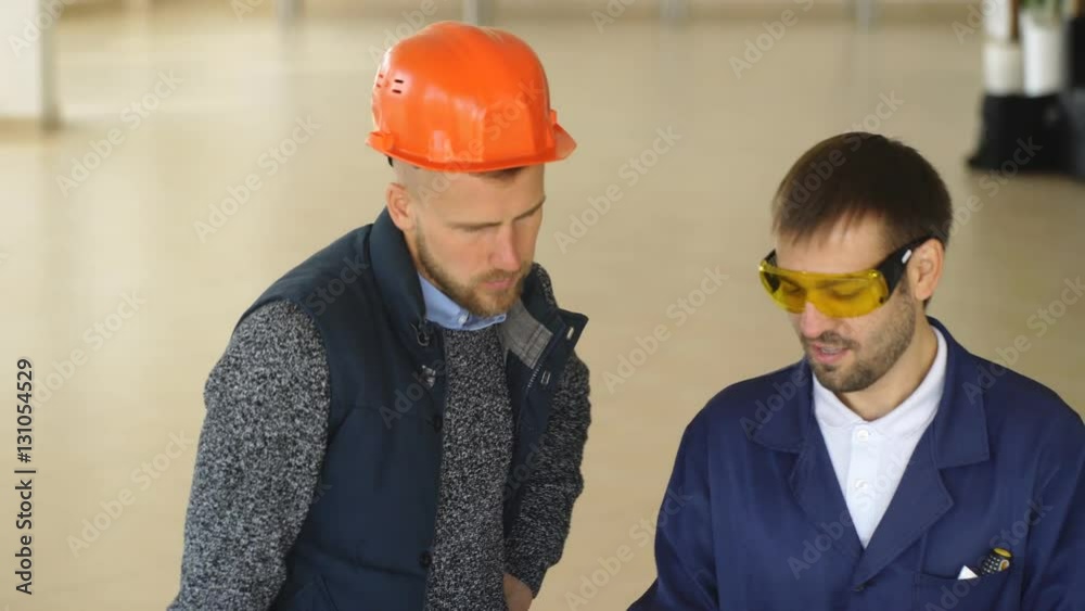 A team of construction workers with orange helmets at work place in a factory A team of construction workers with orange helmets at work place in a factory