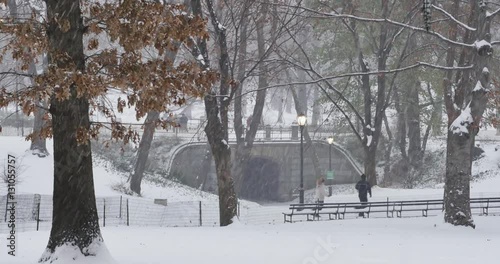 Joggers run on the pathways of Manhattan's Central Park during a December winter snowstorm.  	