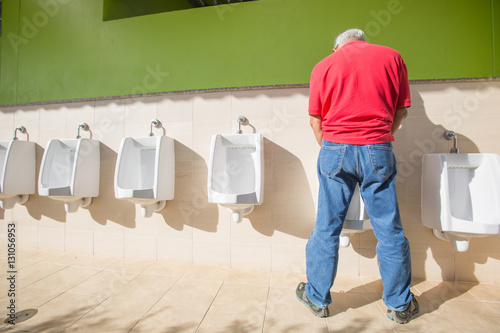 a man peeing standing up in the restroom © ittipol