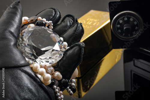 Canvas Print Home invasion and burglary concept with hand in leather gloves holding the loot