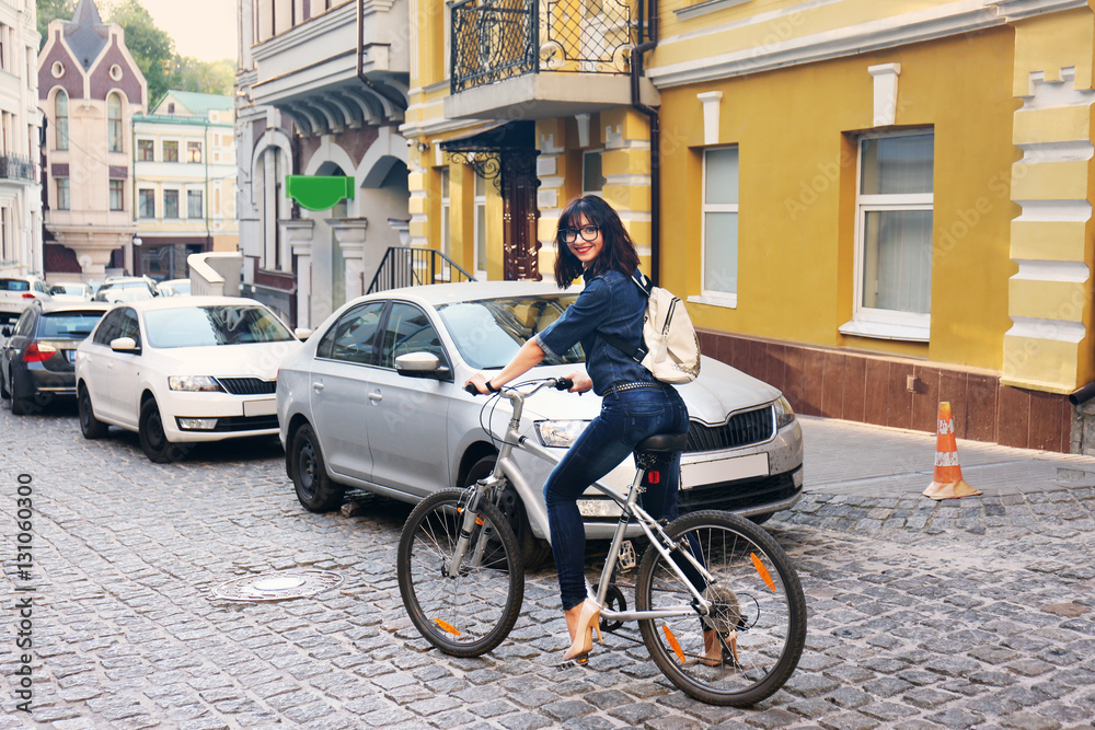 Fototapeta premium Pretty young woman riding bike outdoors