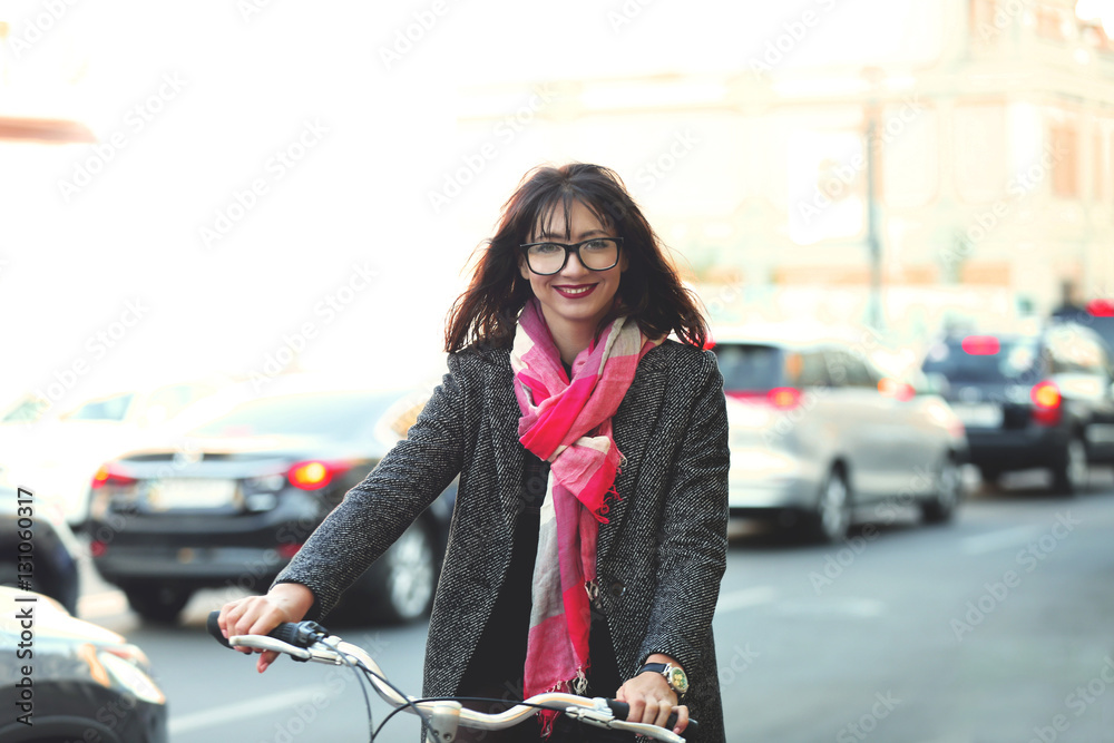 Fototapeta premium Pretty young woman riding bike outdoors