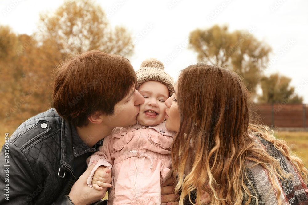 Happy young family having fun outdoors, close up view Happy young family having fun outdoors, close up view