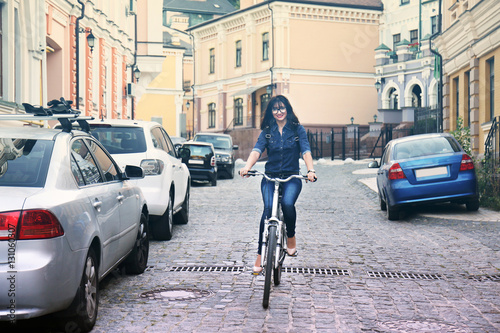 Pretty young woman riding bike outdoors