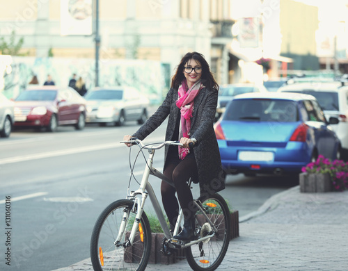 Pretty young woman riding bike outdoors © Africa Studio