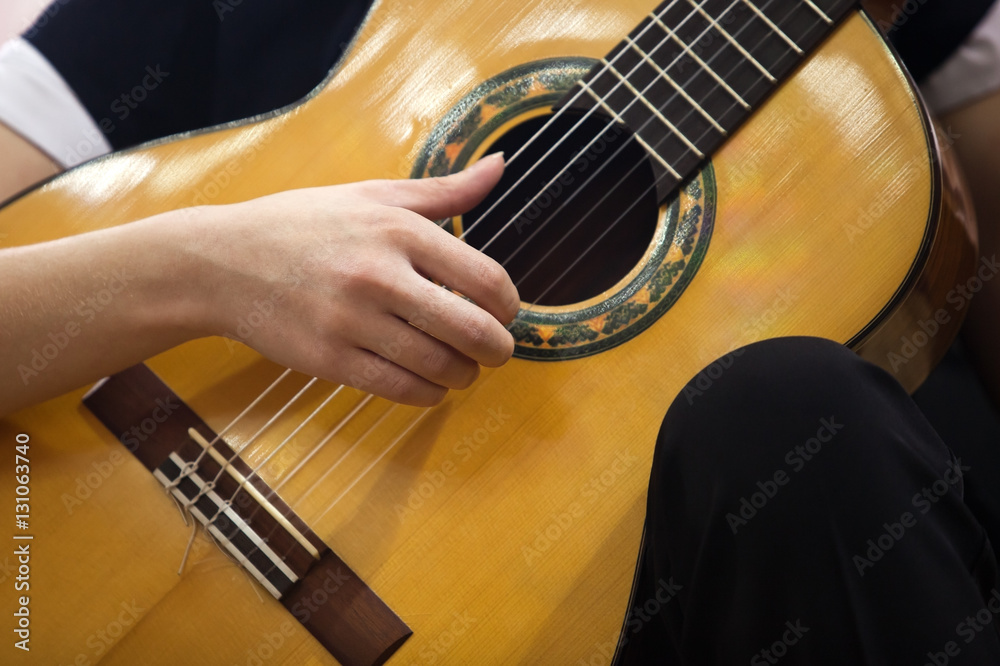 Fototapeta premium Hand girl playing guitar closeup