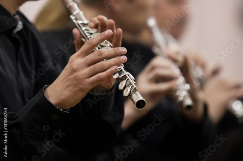 Photo Hands musician playing the flute in the orchestra closeup