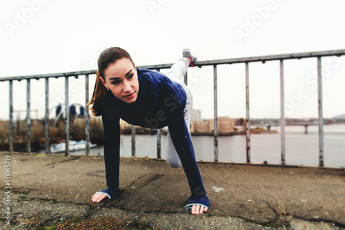Sports girl doing push ups on the bridge