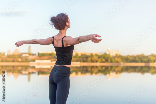 woman enjoying sunset with arms outspread and face raised in sky