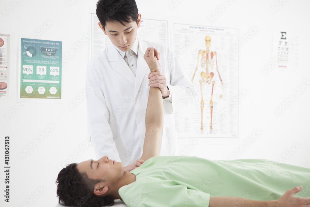 Obraz premium The doctor is examining the male's shoulder joint